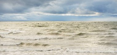 Fırtına sırasında Baltık Denizi. Dramatik gökyüzü, karanlık, parlak bulutlar. Dalgalar, su sıçramaları. Idyllic deniz manzarası. İklim değişikliği, doğa, kararsız hava, ekoloji