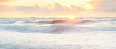 Deniz dalgaları ve sıçrama dokusu. Renkli gökyüzü suya yansıyor. Idyllic deniz manzarası. Kavramsal görüntü, uzun pozlama. Resimli bir manzara var. Arkaplan, duvar kağıdı, doğal desen, grafik kaynakları