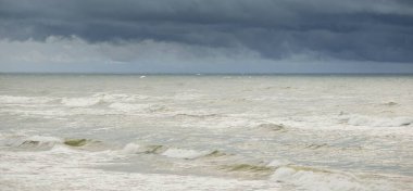 Fırtına sırasında Baltık Denizi. Dramatik gökyüzü, karanlık, parlak bulutlar. Dalgalar, su sıçramaları. Idyllic deniz manzarası. İklim değişikliği, doğa, kararsız hava, ekoloji