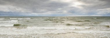 Fırtına sırasında Baltık Denizi. Dramatik gökyüzü, karanlık, parlak bulutlar. Dalgalar, su sıçramaları. Idyllic deniz manzarası. İklim değişikliği, doğa, kararsız hava, ekoloji