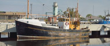 Eski bir ahşap klasik Kuzey Denizi balıkçı teknesi yat limanındaki bir rıhtıma demirlemiş. Denizcilik gemisi, ulaşım, geleneksel zanaat, sanayi