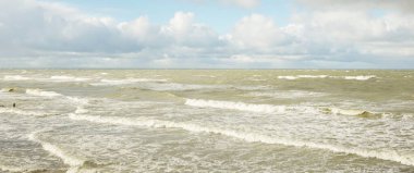 Fırtınadan sonra dramatik günbatımı bulutları altında Baltık Denizi. Dalgalar, su sıçratma. Destansı deniz manzarası. 40-50 deniz mili rüzgar gücü. Kasırga, fırtına, sert hava, meteoroloji, ekoloji, iklim değişikliği