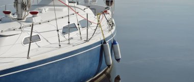 Mavi yelkenli yelkenli (kiralık ve satılık) yat limanındaki bir rıhtıma demirlemişti. Deniz aracı, ulaşım, amatör yelkencilik, spor, boş zaman aktivitesi, tatiller, gezinti, eğlence kavramları.