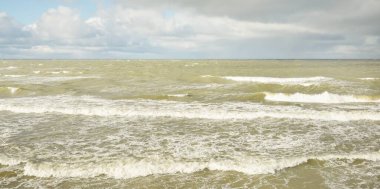Fırtınadan sonra dramatik günbatımı bulutları altında Baltık Denizi. Dalgalar, su sıçratma. Destansı deniz manzarası. Kasırga, fırtına, sert hava, meteoroloji, ekoloji, iklim değişikliği, doğal olaylar