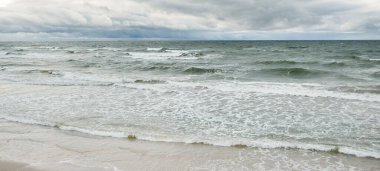 Fırtına sırasında Baltık Denizi. Dramatik gökyüzü, karanlık, parlak bulutlar. Dalgalar, su sıçramaları. Idyllic deniz manzarası. İklim değişikliği, doğa, kararsız hava, ekoloji