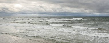 Fırtına sırasında Baltık Denizi. Dramatik gökyüzü, karanlık, parlak bulutlar. Dalgalar, su sıçramaları. Idyllic deniz manzarası. İklim değişikliği, doğa, kararsız hava, ekoloji