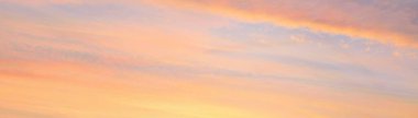 Parlayan pembe, altın rengi sirrus ve kümülüs bulutlarıyla açık mavi gökyüzü. Gün doğumu. Dramatik bulut manzarası. Sanat, meteoroloji, cennet, umut, barış, grafik kaynakları, resimli panoramik manzara