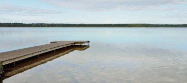 Orman nehri (göl) güneşli bir günde. Ahşap iskele. Clea gökyüzü, kristal berrak suda yansıyor. Idyllic manzara, kırsal manzara. Doğa, ekoloji, eko-turizm, yürüyüş, ekoloji beldesi, yerel turizm