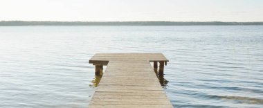 Orman nehri (göl) güneşli bir günde. Ahşap iskele. Clea gökyüzü, kristal berrak suda yansıyor. Idyllic manzara, kırsal manzara. Doğa, ekoloji, eko-turizm, yürüyüş, ekoloji beldesi, yerel turizm