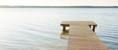 Orman nehri (göl) güneşli bir günde. Ahşap iskele. Clea gökyüzü, kristal berrak suda yansıyor. Idyllic manzara, kırsal manzara. Doğa, ekoloji, eko-turizm, yürüyüş, ekoloji beldesi, yerel turizm