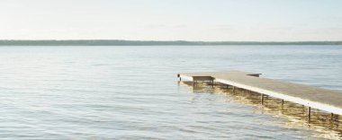 Orman nehri (göl) güneşli bir günde. Ahşap iskele. Clea gökyüzü, kristal berrak suda yansıyor. Idyllic manzara, kırsal manzara. Doğa, ekoloji, eko-turizm, yürüyüş, ekoloji beldesi, yerel turizm