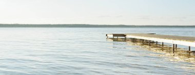 Orman nehri (göl) güneşli bir günde. Ahşap iskele. Clea gökyüzü, kristal berrak suda yansıyor. Idyllic manzara, kırsal manzara. Doğa, ekoloji, eko-turizm, yürüyüş, ekoloji beldesi, yerel turizm