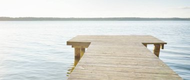 Orman nehri (göl) güneşli bir günde. Ahşap iskele. Clea gökyüzü, kristal berrak suda yansıyor. Idyllic manzara, kırsal manzara. Doğa, ekoloji, eko-turizm, yürüyüş, ekoloji beldesi, yerel turizm