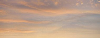 Parlayan pembe, altın rengi sirrus ve kümülüs bulutlarıyla açık mavi gökyüzü. Gün doğumu. Dramatik bulut manzarası. Sanat, meteoroloji, cennet, umut, barış, grafik kaynakları, resimli panoramik manzara