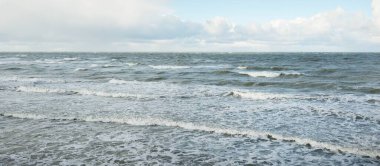 Fırtınadan sonra dramatik günbatımı bulutları altında Baltık Denizi. Dalgalar, su sıçratma. Destansı deniz manzarası. Kasırga, fırtına, sert hava, meteoroloji, ekoloji, iklim değişikliği, doğal olaylar