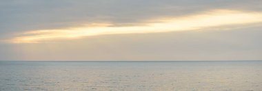 Gün batımında Baltık kıyılarından panoramik hava manzarası. Dramatik bulutlar, parlayan bulutlar, fırtınadan sonra altın güneş ışığı. Doğa, çevre, iklim değişikliği, kararsız hava