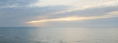 Gün batımında Baltık kıyılarından panoramik hava manzarası. Dramatik bulutlar, parlayan bulutlar, fırtınadan sonra altın güneş ışığı. Doğa, çevre, iklim değişikliği, kararsız hava