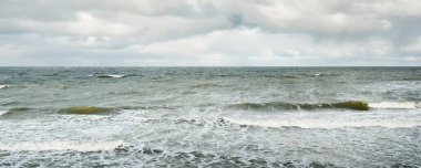 Fırtınadan sonra dramatik günbatımı bulutları altında Baltık Denizi. Dalgalar, su sıçratma. Destansı deniz manzarası. 40-50 deniz mili rüzgar gücü. Kasırga, fırtına, sert hava, meteoroloji, ekoloji, iklim değişikliği