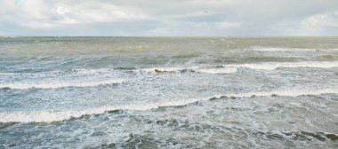 Fırtınadan sonra dramatik günbatımı bulutları altında Baltık Denizi. Dalgalar, su sıçratma. Destansı deniz manzarası. 40-50 deniz mili rüzgar gücü. Kasırga, fırtına, sert hava, meteoroloji, ekoloji, iklim değişikliği