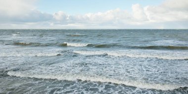 Fırtınadan sonra dramatik günbatımı bulutları altında Baltık Denizi. Dalgalar, su sıçratma. Destansı deniz manzarası. Kasırga, fırtına, sert hava, meteoroloji, ekoloji, iklim değişikliği, doğal olaylar