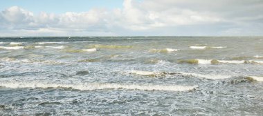 Fırtınadan sonra dramatik günbatımı bulutları altında Baltık Denizi. Dalgalar, su sıçratma. Destansı deniz manzarası. 40-50 deniz mili rüzgar gücü. Kasırga, fırtına, sert hava, meteoroloji, ekoloji, iklim değişikliği