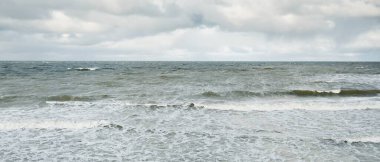Fırtınadan sonra dramatik günbatımı bulutları altında Baltık Denizi. Dalgalar, su sıçratma. Destansı deniz manzarası. 40-50 deniz mili rüzgar gücü. Kasırga, fırtına, sert hava, meteoroloji, ekoloji, iklim değişikliği