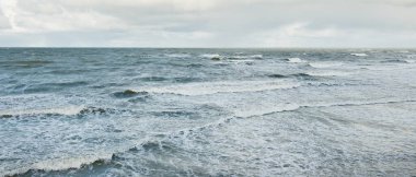 Fırtınadan sonra dramatik günbatımı bulutları altında Baltık Denizi. Dalgalar, su sıçratma. Destansı deniz manzarası. 40-50 deniz mili rüzgar gücü. Kasırga, fırtına, sert hava, meteoroloji, ekoloji, iklim değişikliği