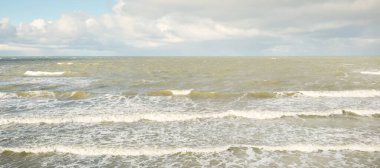 Fırtınadan sonra dramatik günbatımı bulutları altında Baltık Denizi. Dalgalar, su sıçratma. Destansı deniz manzarası. Kasırga, fırtına, sert hava, meteoroloji, ekoloji, iklim değişikliği, doğal olaylar