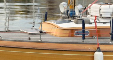 Modern klasik ahşap İsveçli yelkenli teknesi yat limanındaki bir iskeleye demirlemiş. Turizm, tatiller, boş zaman aktiviteleri, eğlence, yelkencilik temaları