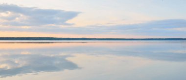 Orman Gölü (nehir) gün batımında. Parlayan bulutlar, berrak bir sudaki simetri yansımaları. Idyllic manzara. Resimli panoramik manzara. Saf doğa, ekoloji, ekolojik rezerv, eko-turizm.