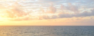 Gün batımında Baltık kıyılarından panoramik manzara. Dramatik bulutlar, parlayan bulutlar, fırtınadan sonra altın güneş ışığı. Doğa, çevre, iklim değişikliği, kararsız hava