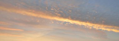 Clear blue sky with glowing pink and golden cirrus and cumulus clouds. Sunrise. Dramatic cloudscape. Concept art, meteorology, heaven, hope, peace, graphic resources, picturesque panoramic scenery