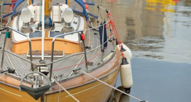 Modern klasik ahşap İsveçli yelkenli teknesi yat limanındaki bir iskeleye demirlemiş. Turizm, tatiller, boş zaman aktiviteleri, eğlence, yelkencilik temaları