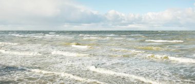 Fırtınadan sonra dramatik günbatımı bulutları altında Baltık Denizi. Dalgalar, su sıçratma. Destansı deniz manzarası. Kasırga, fırtına, sert hava, meteoroloji, ekoloji, iklim değişikliği, doğal olaylar