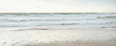 Gün batımında Baltık kıyısı. Açık günbatımı gökyüzü, parlayan bulutlar. Idyllic manzara. Doğa, tatiller, eğlence. Çevre turizmi. Panoramik görünüm