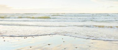 Gün batımında Baltık kıyısı. Açık günbatımı gökyüzü, parlayan bulutlar. Idyllic manzara. Doğa, tatiller, eğlence. Çevre turizmi. Panoramik görünüm