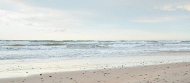 Gün batımında Baltık kıyısı. Açık günbatımı gökyüzü, parlayan bulutlar. Idyllic manzara. Doğa, tatiller, eğlence. Çevre turizmi. Panoramik görünüm