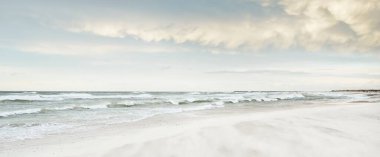 Gün batımında Baltık kıyısı. Açık günbatımı gökyüzü, parlayan bulutlar. Idyllic manzara. Doğa, tatiller, eğlence. Çevre turizmi. Panoramik görünüm