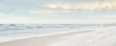 Gün batımında Baltık kıyısı. Açık günbatımı gökyüzü, parlayan bulutlar. Idyllic manzara. Doğa, tatiller, eğlence. Çevre turizmi. Panoramik görünüm