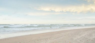 Gün batımında Baltık kıyısı. Açık günbatımı gökyüzü, parlayan bulutlar. Idyllic manzara. Doğa, tatiller, eğlence. Çevre turizmi. Panoramik görünüm