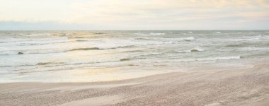 Gün batımında Baltık kıyısı. Açık günbatımı gökyüzü, parlayan bulutlar. Idyllic manzara. Doğa, tatiller, eğlence. Çevre turizmi. Panoramik görünüm