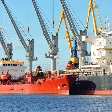 Kargo gemileri iskele terminaline yükleniyor. Vinçler arka planda. Baltık Denizi. Bunkering, akaryakıt ve enerji üretimi, arz, teknoloji, lojistik, hizmet, sanayi, ticaret