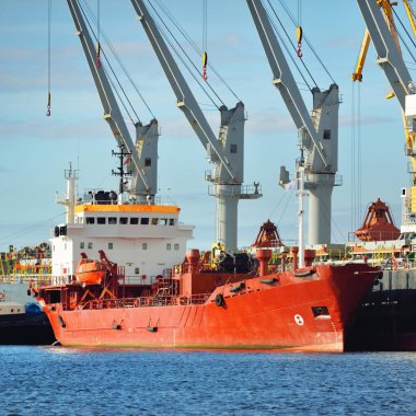 Kargo gemileri iskele terminaline yükleniyor. Vinçler arka planda. Baltık Denizi. Bunkering, akaryakıt ve enerji üretimi, arz, teknoloji, lojistik, hizmet, sanayi, ticaret