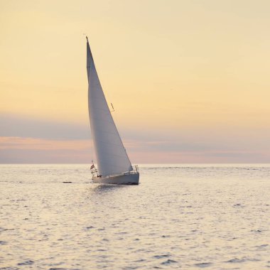 Günbatımında Baltık Denizi 'nde yelkenli yelkenli yelkenli. Fırtınadan sonra gökyüzü açık, altın güneş ışığı. Ulaşım, seyahat, gezi, spor, eğlence, boş zaman aktivitesi, yarış, yelkenli yarışı