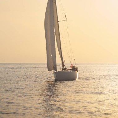 Günbatımında Baltık Denizi 'nde yelkenli yelkenli yelkenli. Fırtınadan sonra gökyüzü açık, altın güneş ışığı. Ulaşım, seyahat, gezi, spor, eğlence, boş zaman aktivitesi, yarış, yelkenli yarışı