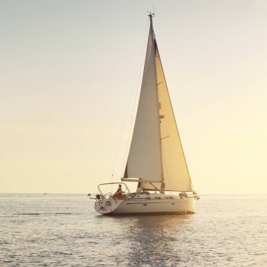 Günbatımında Baltık Denizi 'nde yelkenli yelkenli yelkenli. Fırtınadan sonra gökyüzü açık, altın güneş ışığı. Ulaşım, seyahat, gezi, spor, eğlence, boş zaman aktivitesi, yarış, yelkenli yarışı