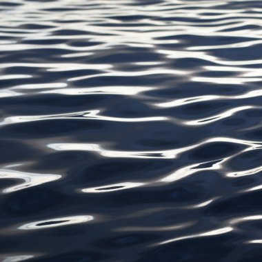 Gün batımında deniz. Karanlık su yüzeyi yakın plan. Soyut doğal desen, doku, arkaplan, duvar kağıdı, grafik kaynaklar, kopyalama alanı, üç boyutlu görüntüleme. Doğa, çevre, turizm, gezi, yüzme konsepti