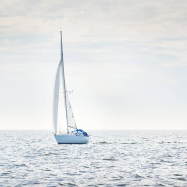 Açık denizde yelkenli yelkenli yelkenli. Gökyüzü açık, bulutlu. Yelkenlinin manzarası. Ulaşım, seyahat, spor, eğlence, boş zaman aktivitesi, yarış, yelkenli yarışı. Panorama, boşluğu kopyala