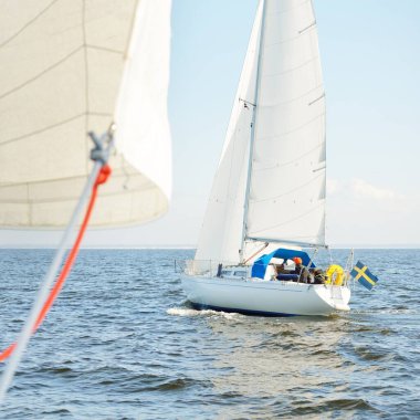 Açık denizde yelkenli yelkenli yelkenli. Gökyüzü açık, bulutlu. Yelkenlinin manzarası. Ulaşım, seyahat, spor, eğlence, boş zaman aktivitesi, yarış, yelkenli yarışı. Panorama, boşluğu kopyala