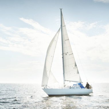 Açık denizde yelkenli yelkenli yelkenli. Gökyüzü açık, bulutlu. Yelkenlinin manzarası. Ulaşım, seyahat, spor, eğlence, boş zaman aktivitesi, yarış, yelkenli yarışı. Panorama, boşluğu kopyala